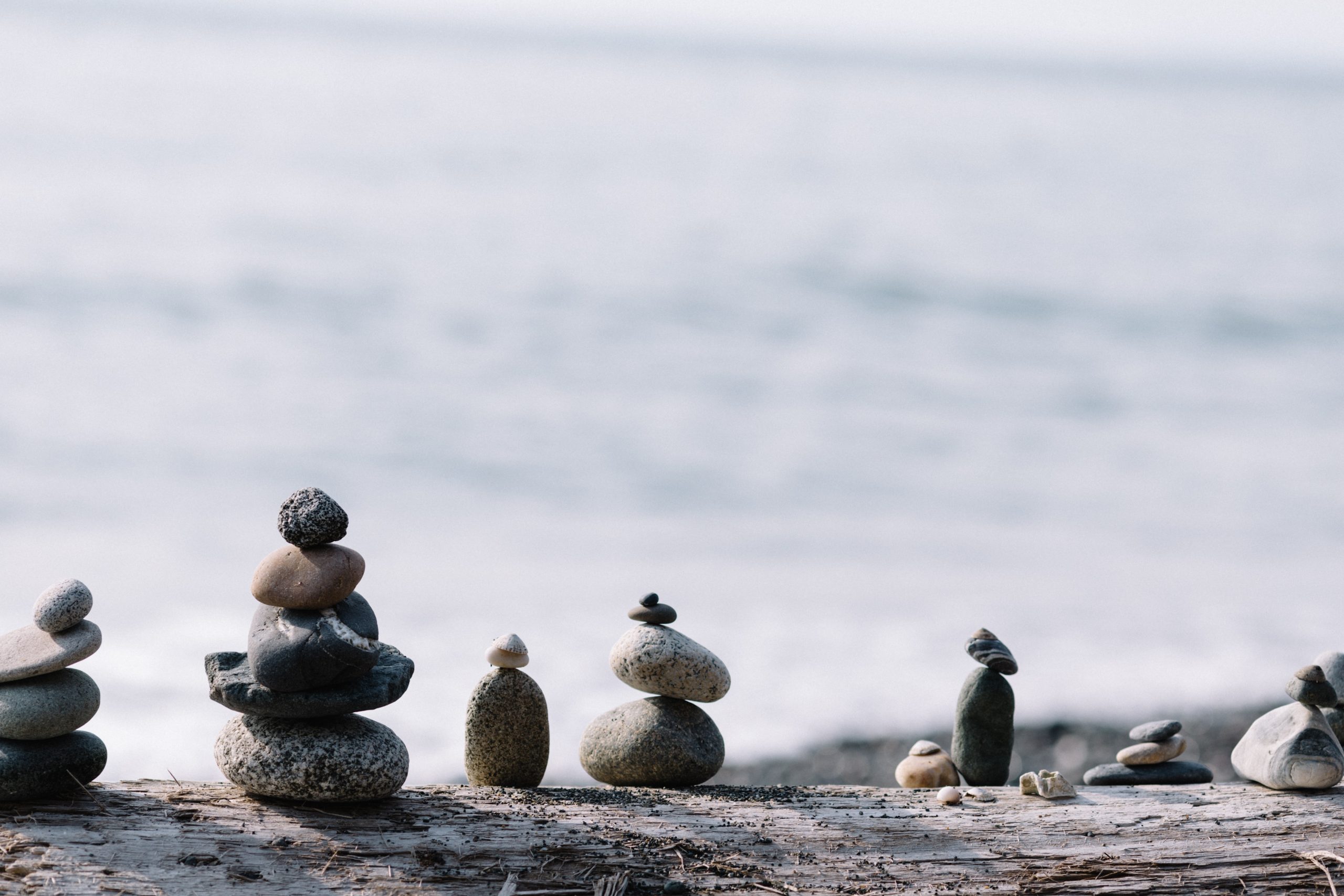 Stones piled atop one another in the foreground, snow in the background.