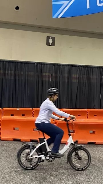 Lori Straus test driving an e-bike on an indoor circuit.