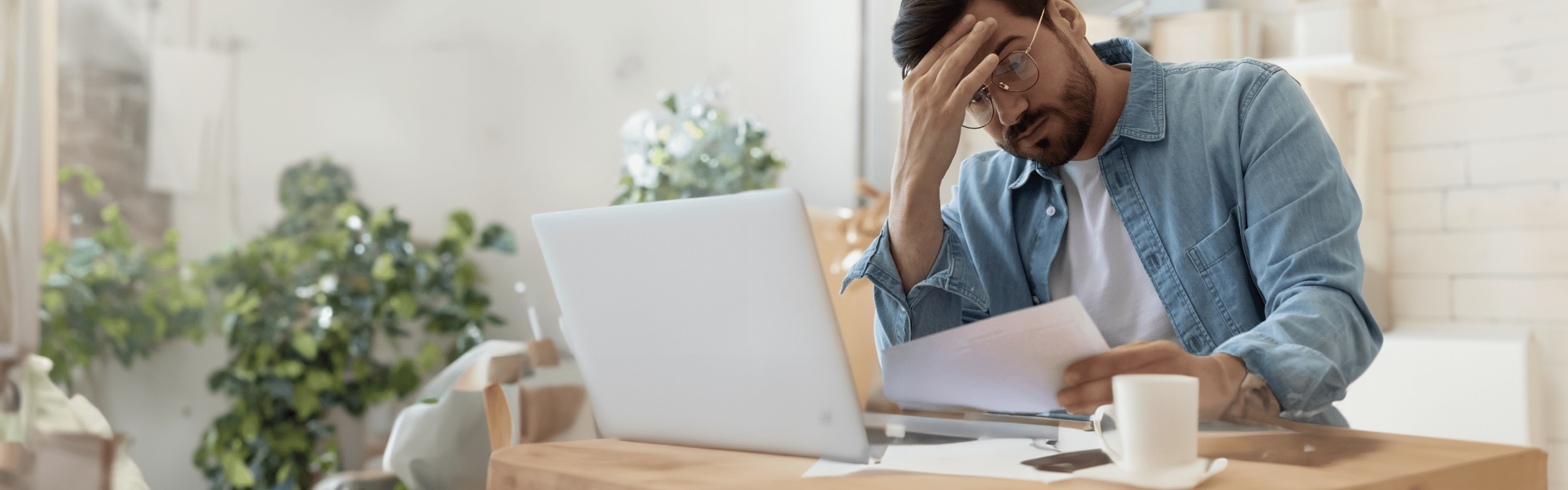 Man looking concerned as he reads a workers' compensation denial