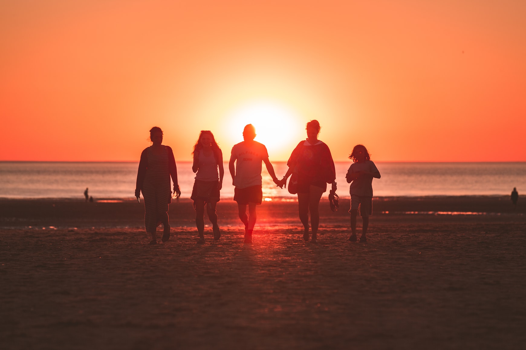 group of 5 people on beach with sunset