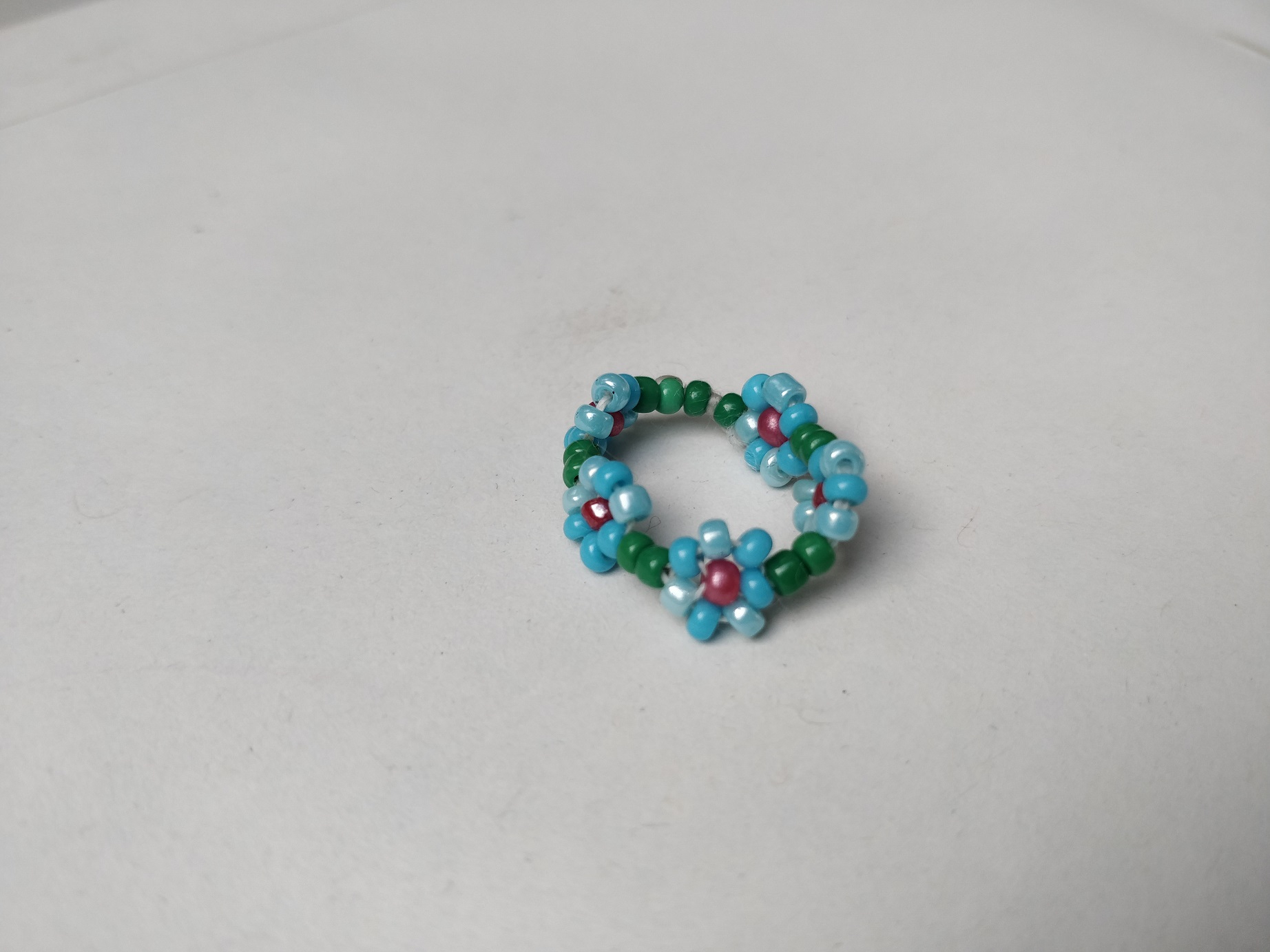 håndsyet fingerring med blomster af perler
