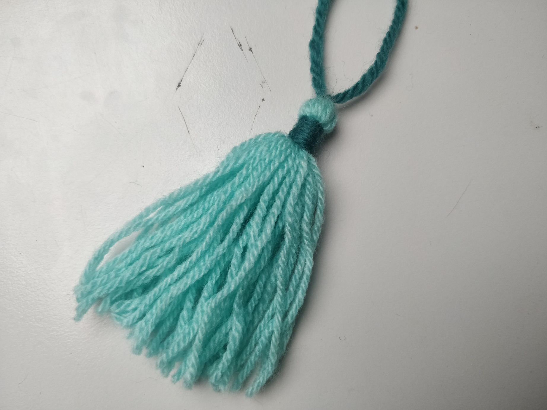 Hjemmelavet kvast af turkis garn