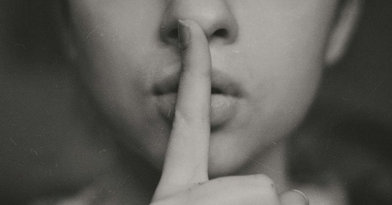 A women with fingers on lips