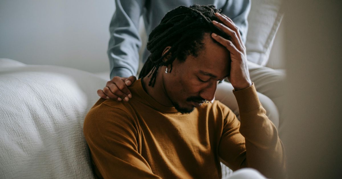 A distressed man being comforted