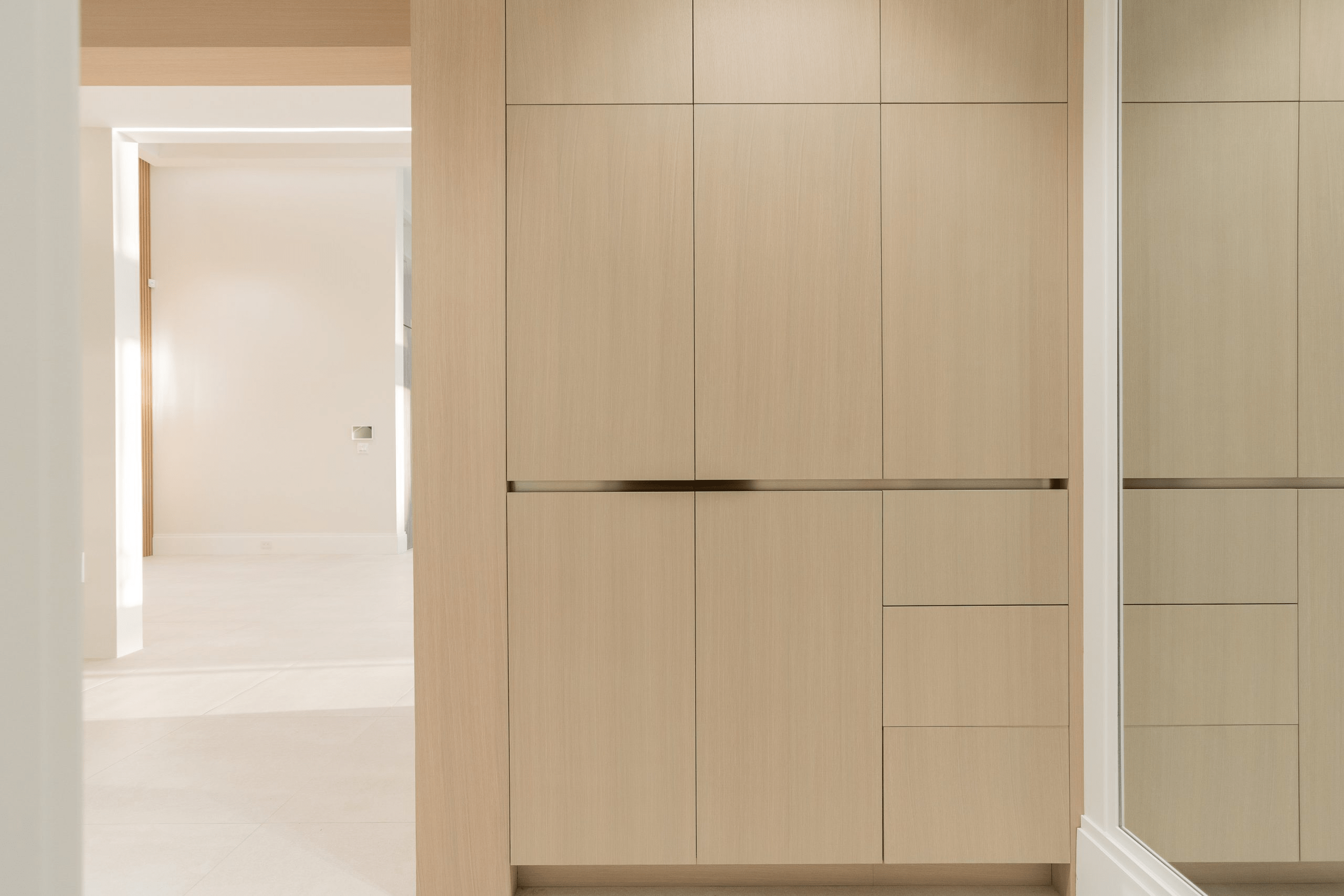 Minimalist built-in storage with light wood panels and clean lines — Luminacraft Cabinets, Kitchener.