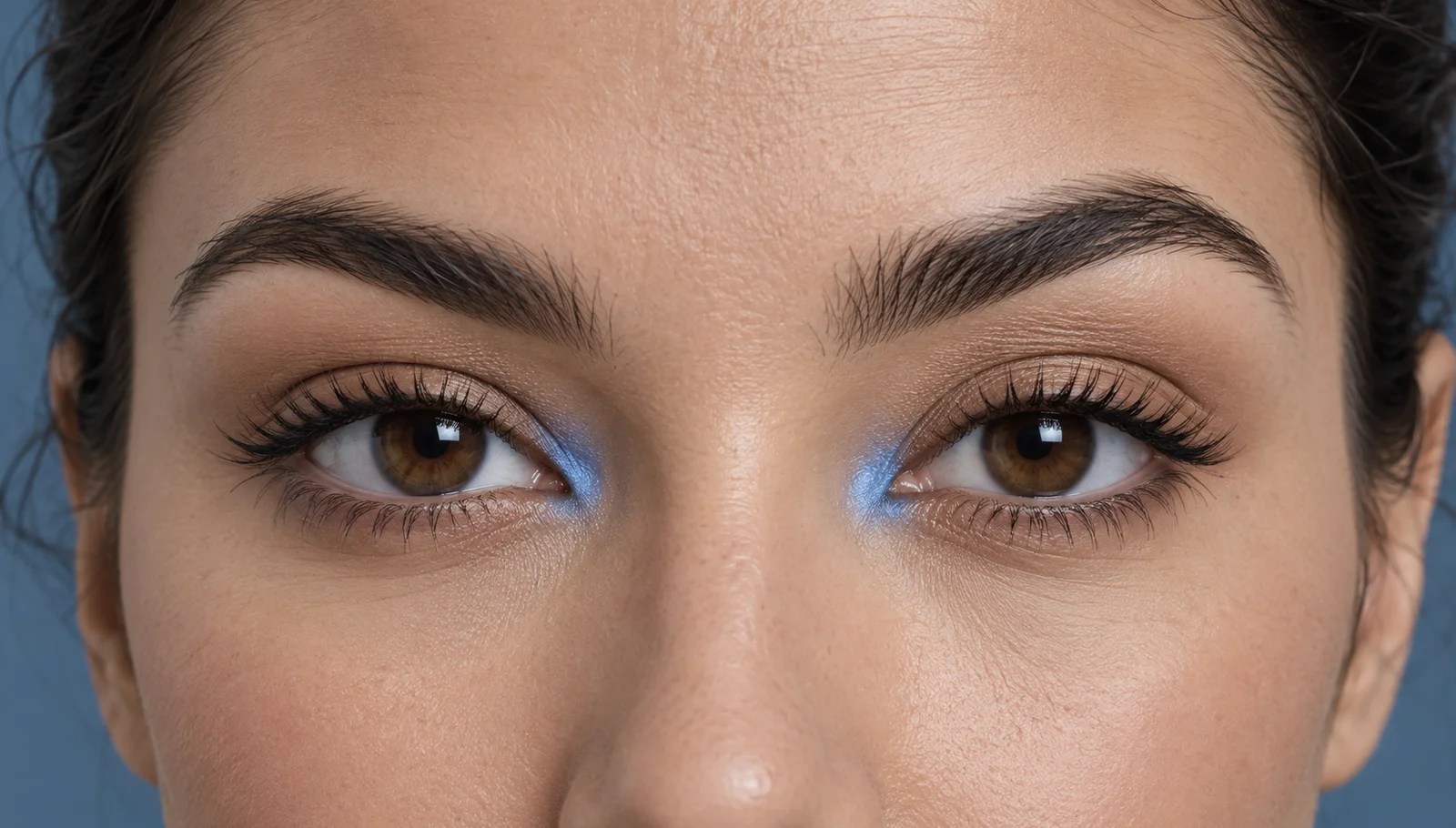 Small cornflower blue eyeshadow accents at the inner corners