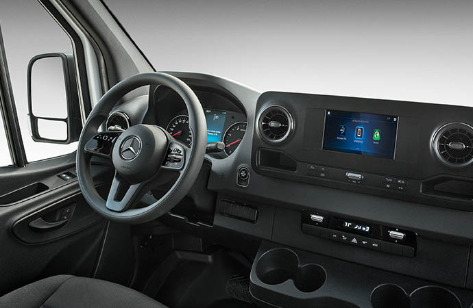 Mercedes-Benz Sprinter interior showing steering wheel, instrument cluster, and touchscreen infotainment display