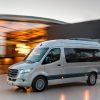 White passenger van driving on a road
