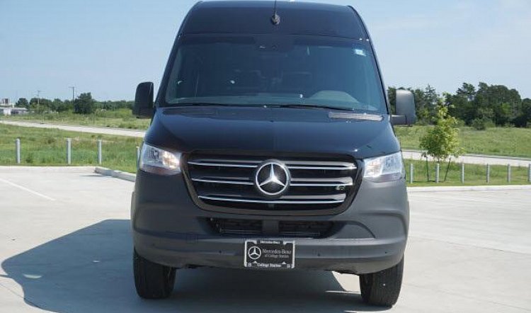 Front view of a dark gray Mercedes-Benz Sprinter van in a parking lot