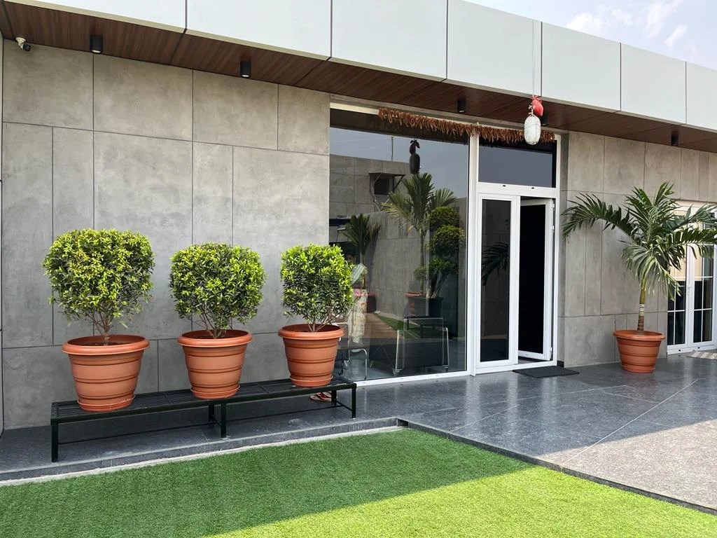 Modern building exterior featuring Luxture's Concrete Facades and potted plants.