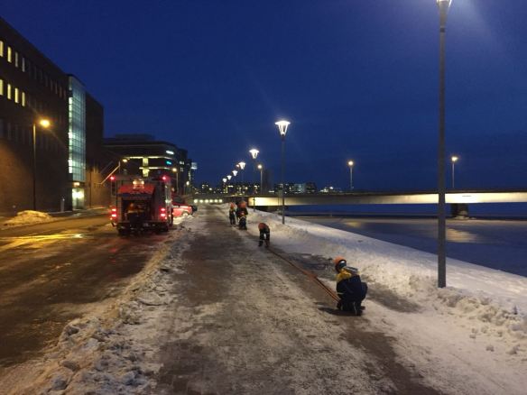 Palokuntanuoret rullaavat letkuja kasaan Lauttasaaren sillan kupeessa