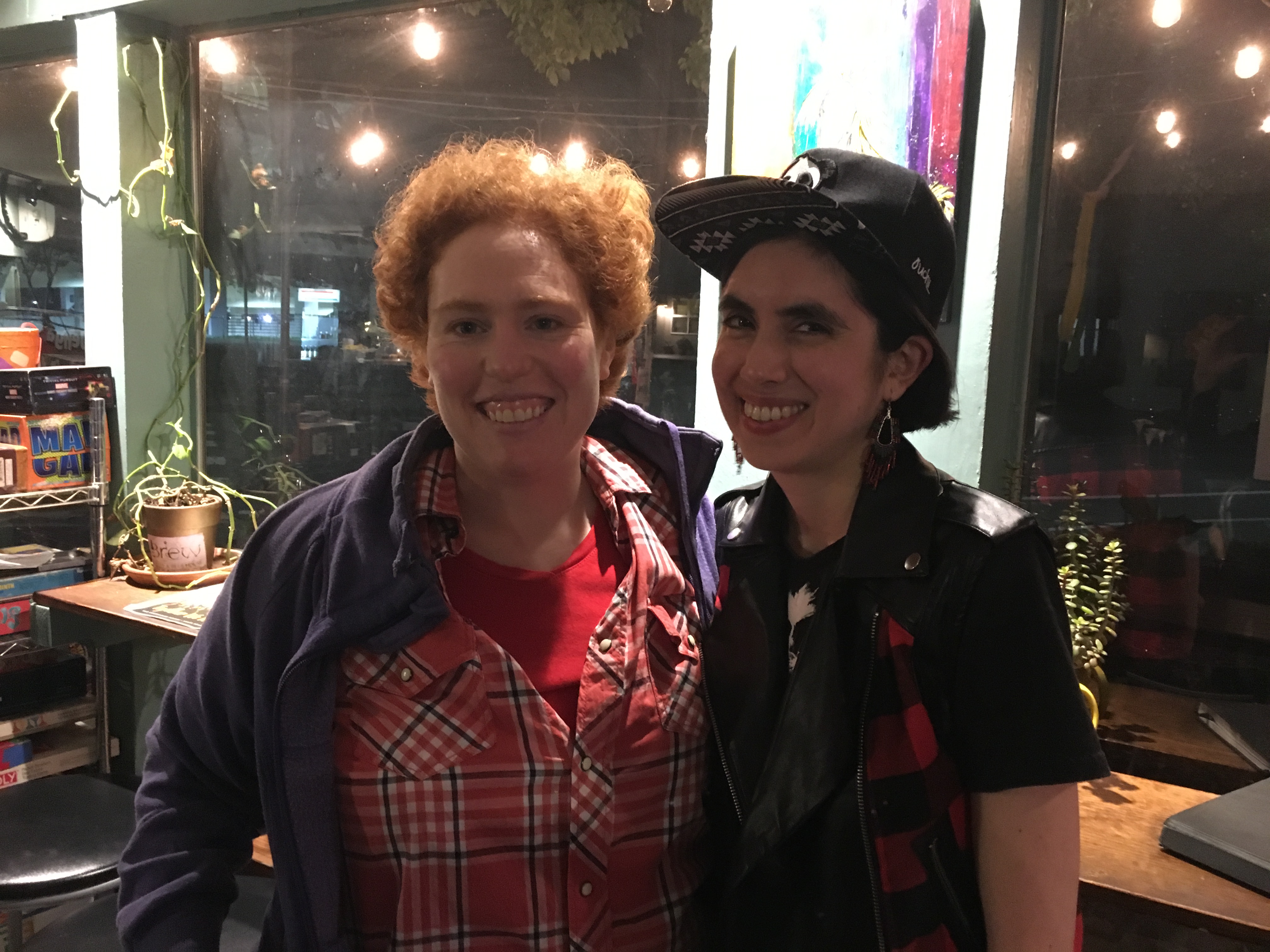 L: Ma'ayan has fair skin and wearing in red western plaid shirt and purple jacket; R: Star in baseball cap and has light brown skin.