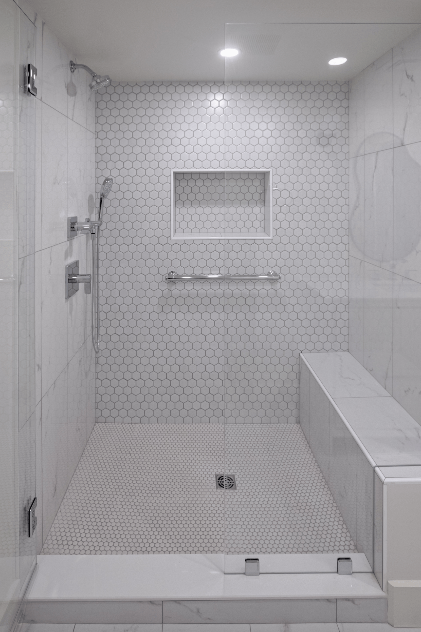 Walk in shower with marble bench and hex tile in a Lexington MA bathroom remodel