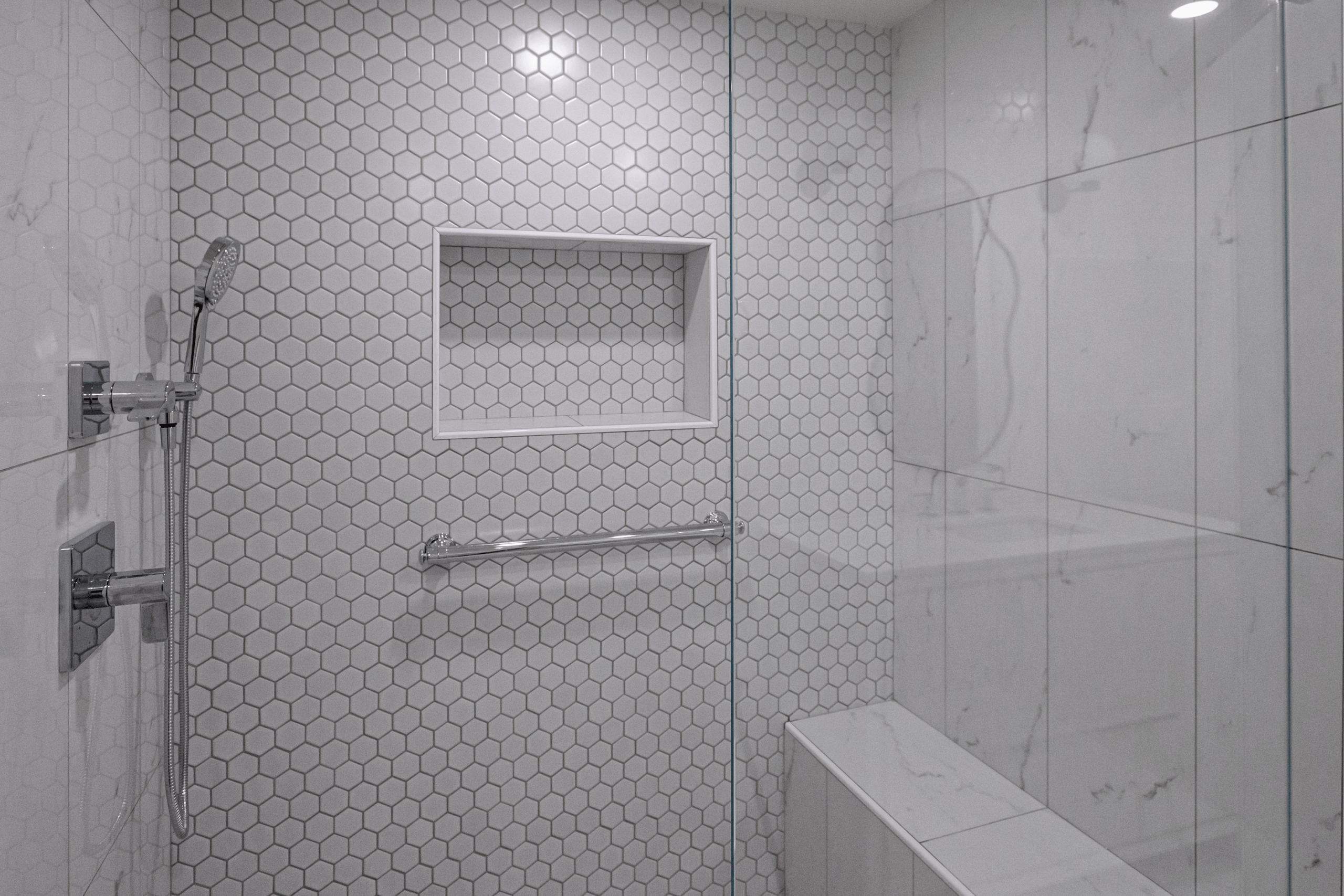 Hex tile shower with recessed niche and grab bar in a Lexington MA bathroom renovation