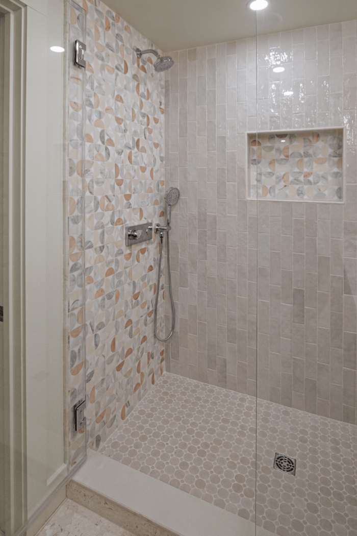 Marble mosaic accent wall and pebble floor shower in a Lexington MA bathroom renovation Marble mosaic accent wall and pebble floor shower in a Lexington MA bathroom renovation