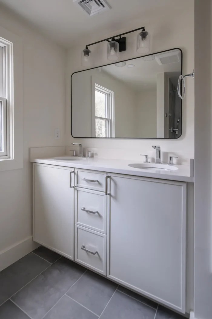 White double vanity with quartz countertop and black framed mirror in Lexington MA