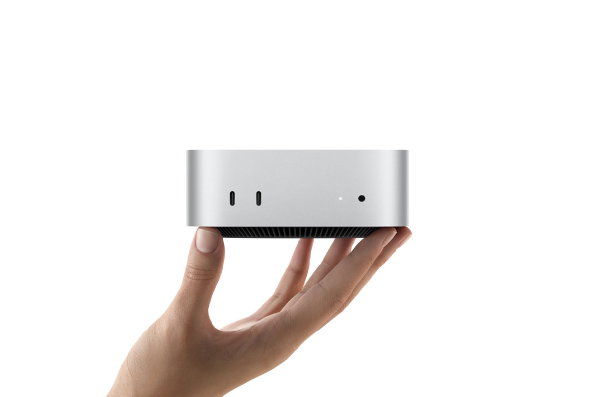 En hand som håller en Mac mini