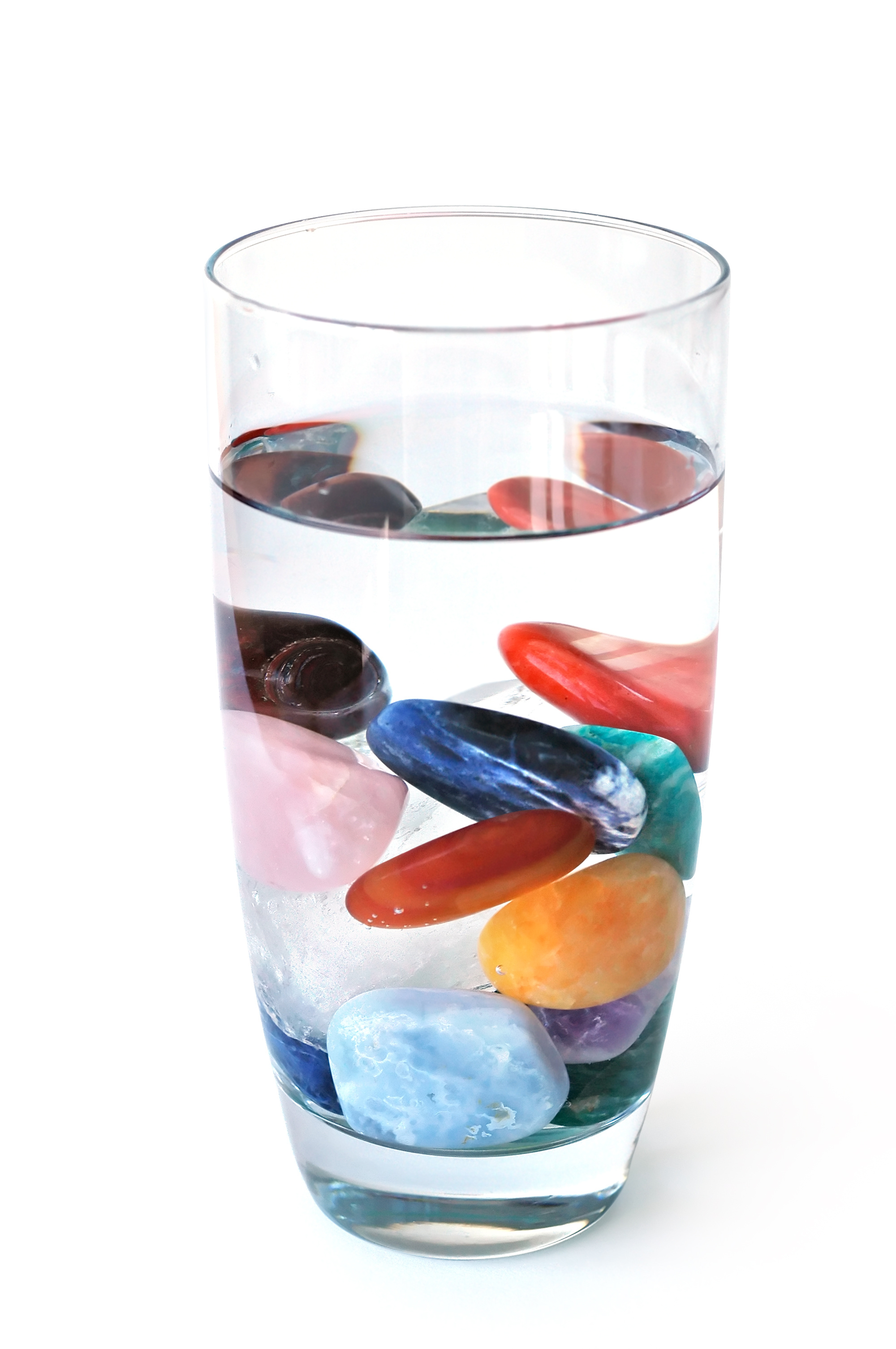 crystals in full filled glass of water, on white