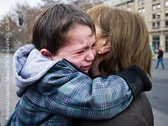 Boy cries in mother's arms. Maybe they have to part.