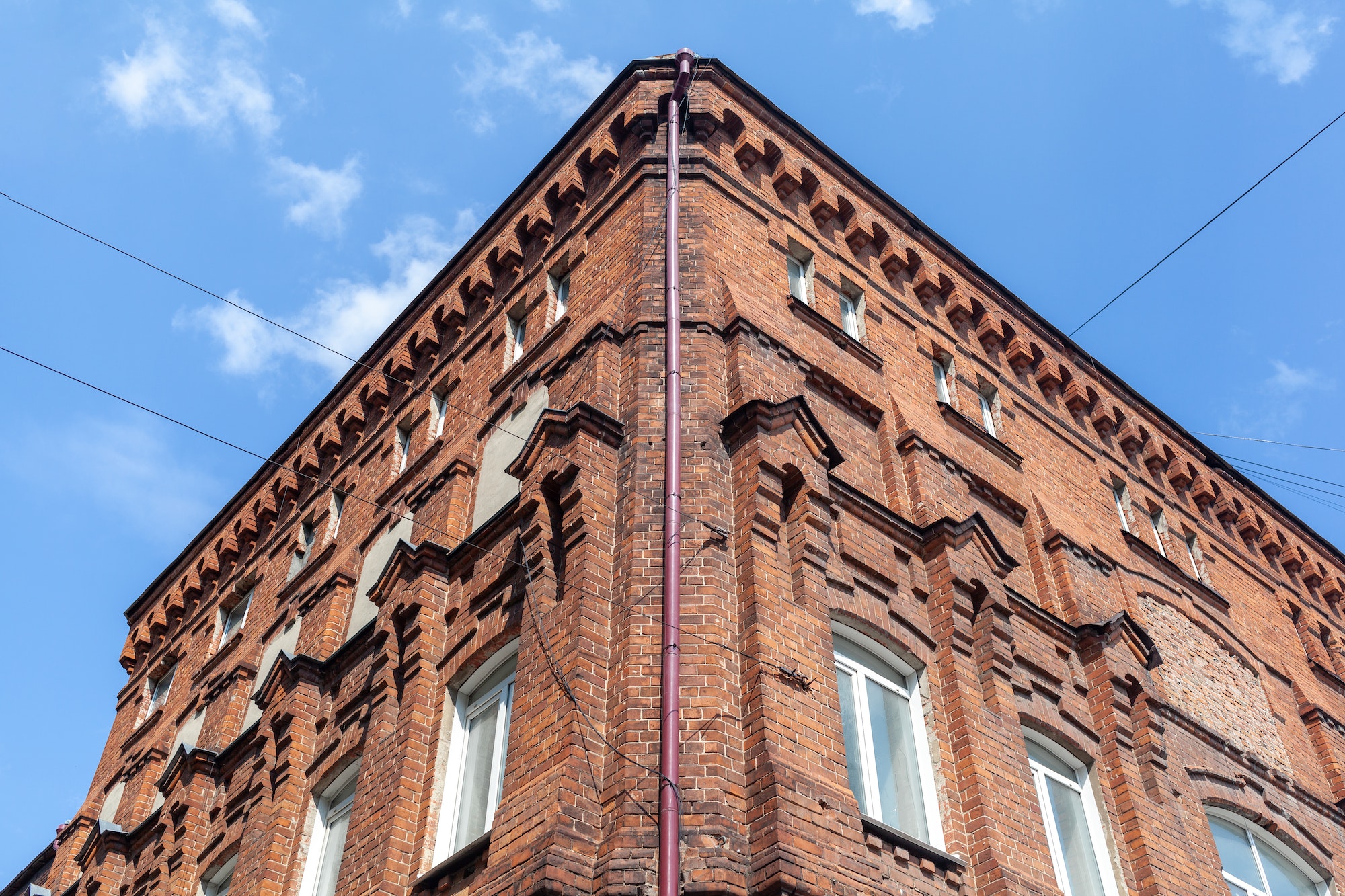 An old large brick building with a white sign for the name of a cafe