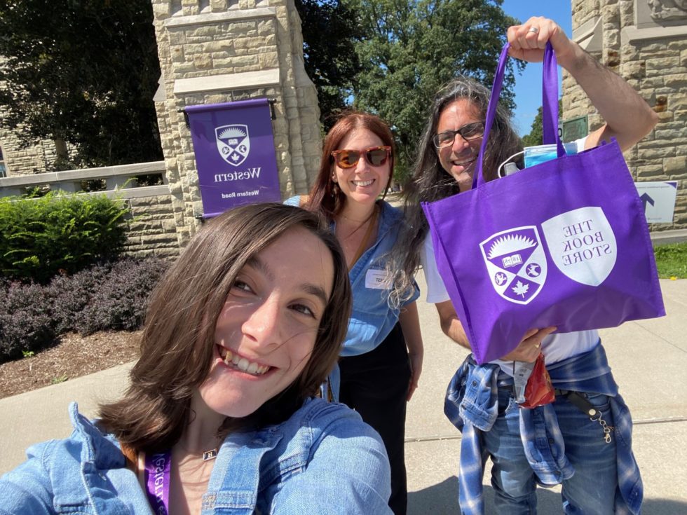 Hannah Alper and her parents with a Western Bookstore bag