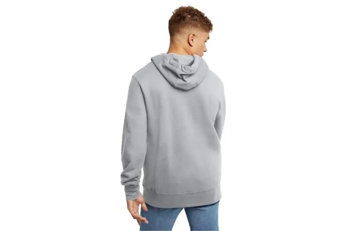 Back view of a person wearing a light gray hoodie and blue jeans.