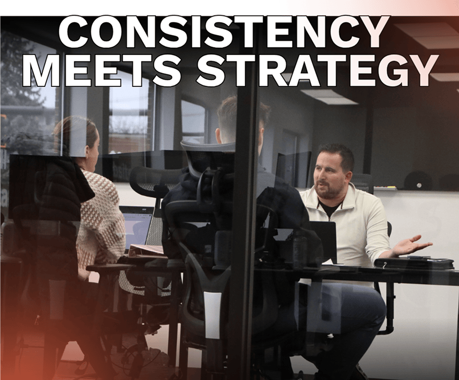 Group discussion in a glass-walled conference room with a bold title: 'Consistency Meets Strategy' across the top.