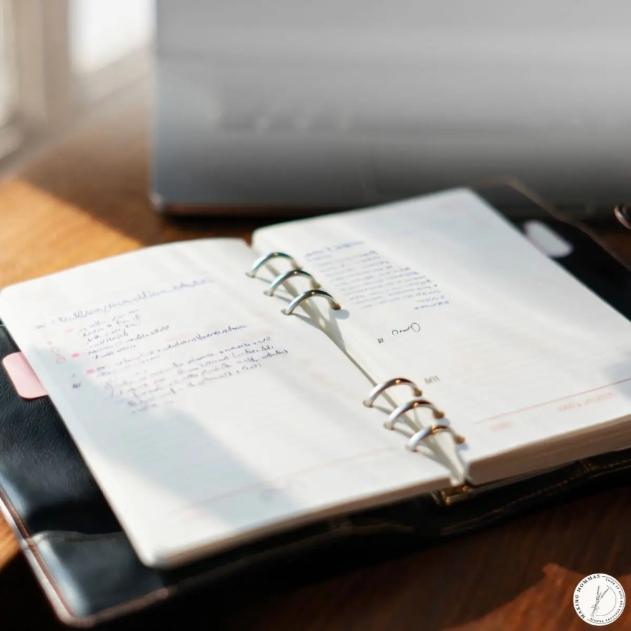 Open notebook with handwritten notes on a table, representing breaking the day into manageable chunks and simple daily routines at home.