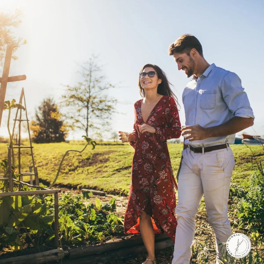 A husband and wife walking together outdoors, smiling and talking while enjoying time together in a garden setting.