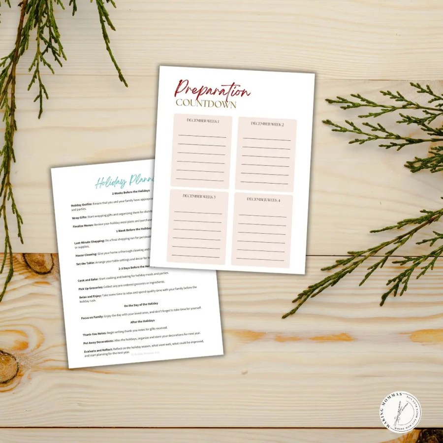 Flat lay of printable holiday planning pages, including a December preparation countdown and detailed holiday checklist, styled on a wooden table with evergreen branches — perfect for organizing Christmas week by week.