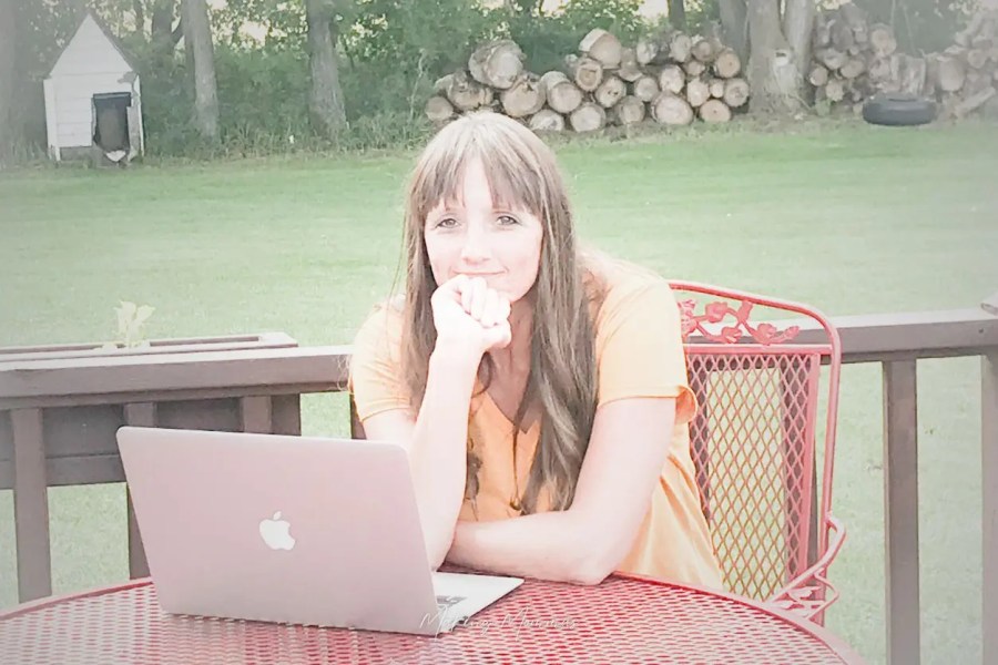 image of a woman sitting on the deck with a computer