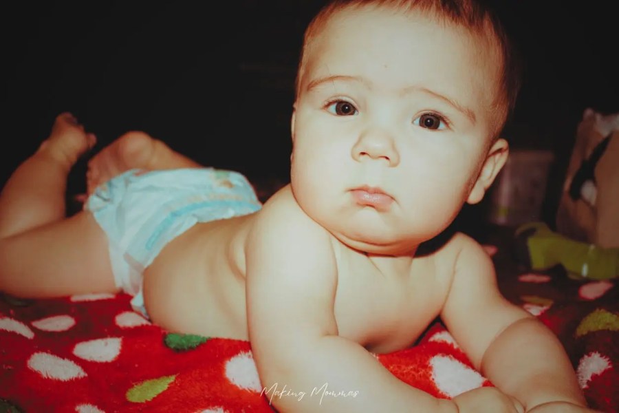 image of a baby laying on a blanket in his diaper