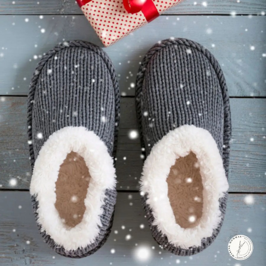 Cozy gray slippers with white fleece lining beside a wrapped Christmas gift — a warm and thoughtful holiday present idea for stay-at-home moms.