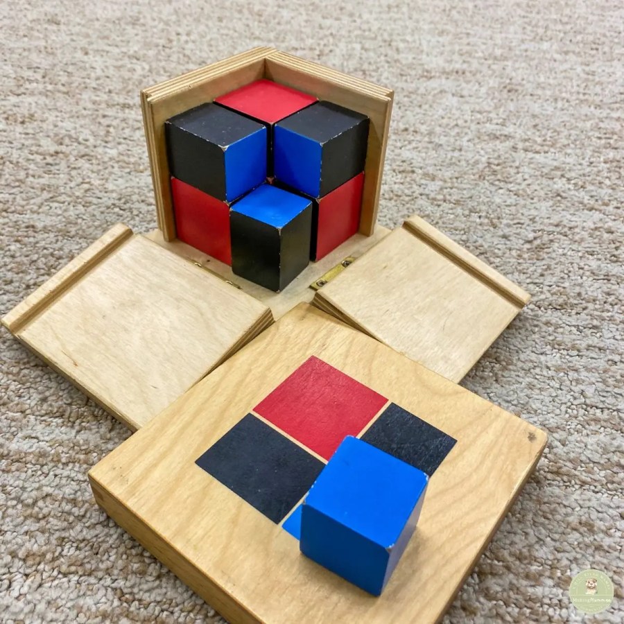 Four simple wooden building blocks stacked on a neutral rug in a sunlit room, illustrating the 4-block framework of a flexible SAHM daily rhythm.