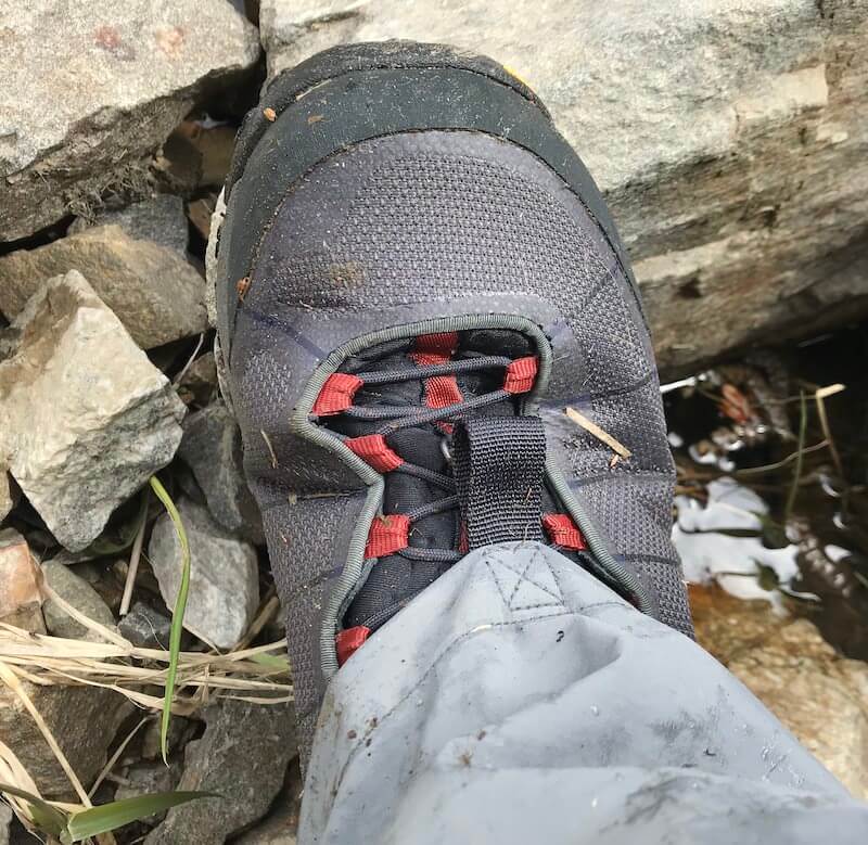 This photo shows a Simms Flyweight Wading Boot from the top while being worn by a fisherman.