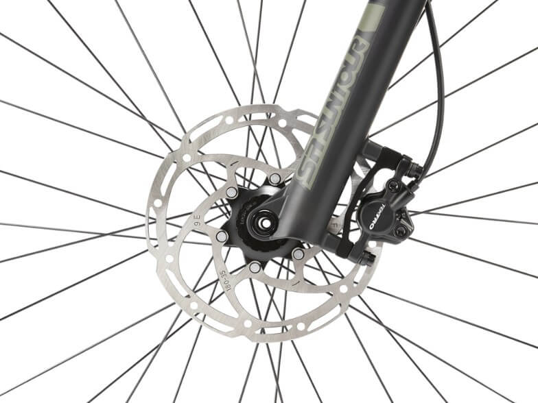 This photo shows a closeup of the front hydraulic brakes on The REI Co-op Cycles DRT 1.2 mountain bike.