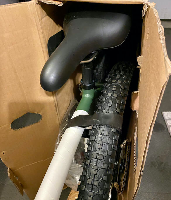This photo shows a partially assembled Vvolt Sirius ebike halfway out of the shipping box.