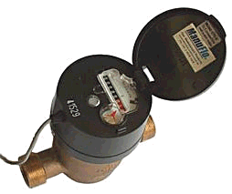 Water meter with a black cover and a visible measurement dial from ManuFlo.
