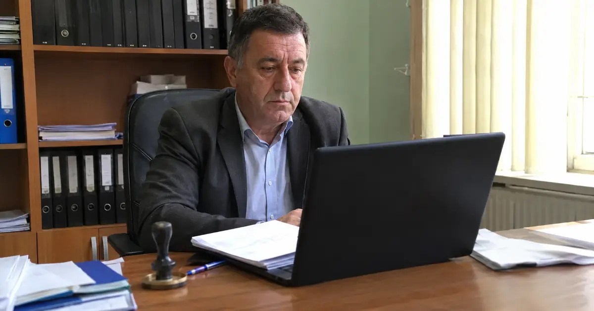 Notar public lucrând la birou, cu dosare și ștampilă alături — SEO local pentru notari, de Marcel Felix
