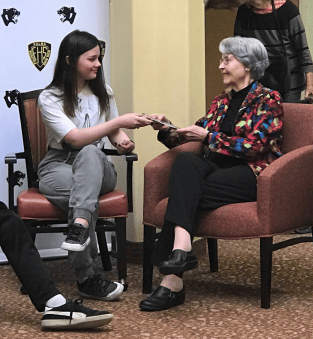Jaylin Bower presents a book to Betty Walker