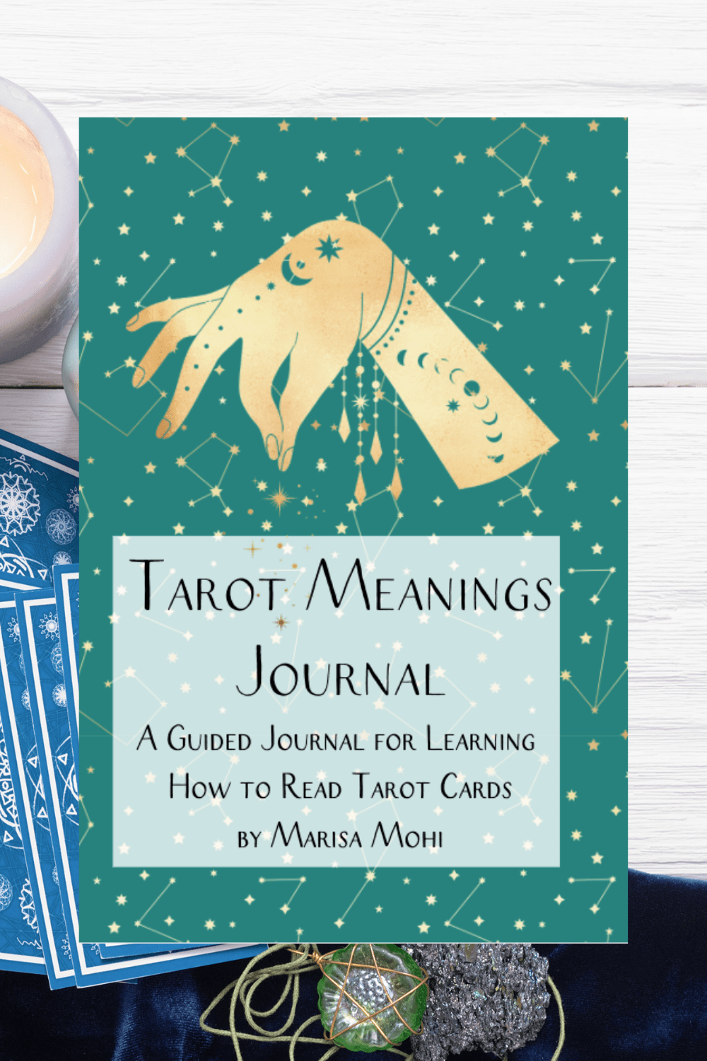 tarot cards laid out with a pendant with the over of the tarot card meanings journal over it