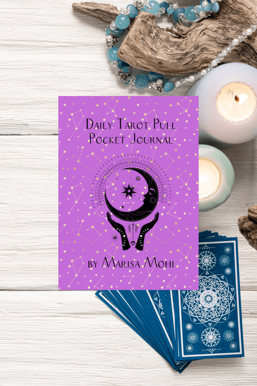 a deck of tarot cards and candles with the cover of the Daily Tarot Pull Pocket Journal
