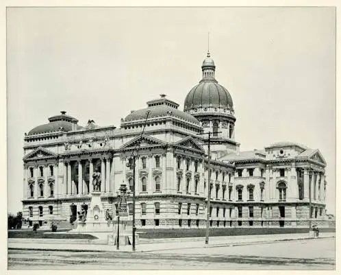 Historic domed government building with neoclassical columns, photographed from the street (black-and-white).
