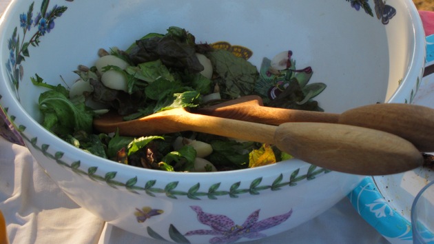 Fred and Kim's Salad a potluck salad in a white bowl with wooden serving spoons