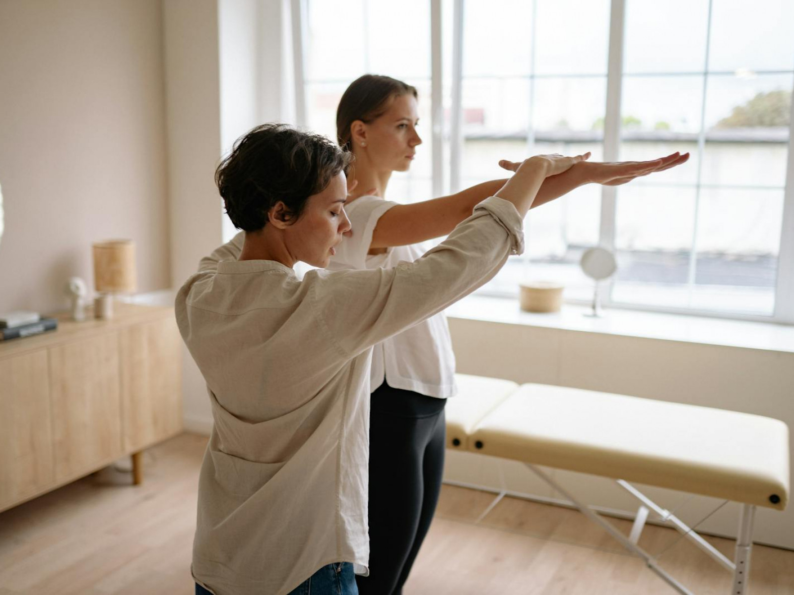 A therapist helps a client with therapeutic exercises in a wellness clinic.