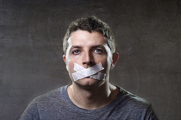 attractive young man with mouth sealed on duct tape to prevent h