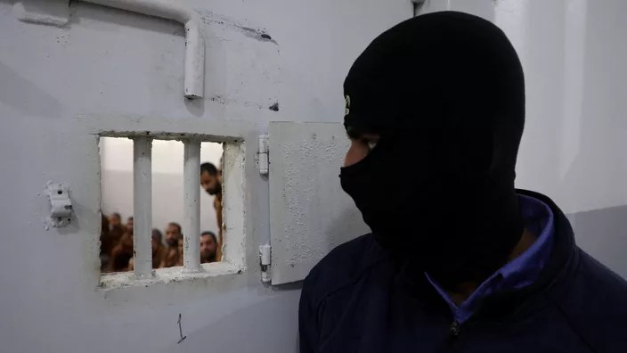 حارس يراقب مقاتلين من تنظيم الدولة الإسلامية محتجزين في سجن الصناعة بالحسكة، شمال شرق سوريا، في 18 يناير. أورهان قره مان / رويترز