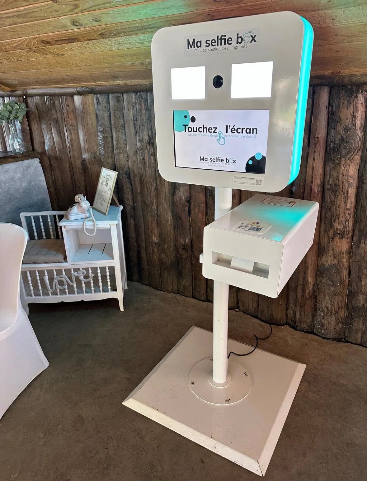 Borne photo Ma Selfie Box installée dans une salle de réception, écran tactile, imprimante thermique et cadre personnalisé pour événements (mariage, séminaire, soirée)