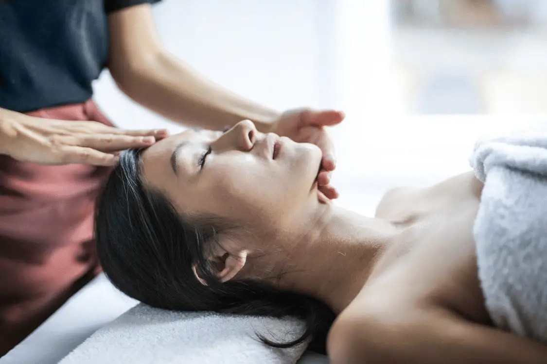 A person getting a scalp massage at a massage spa