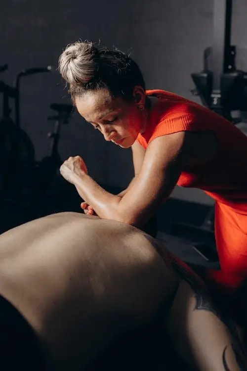 A massage therapist pressing on a client’s back to relieve trigger points.